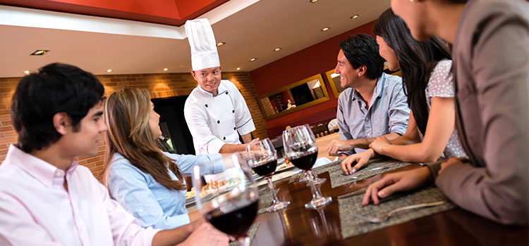 chef visiting table of patrons at restaurant