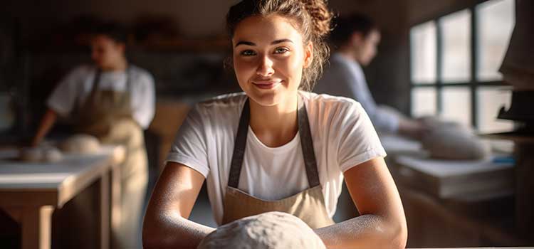baking and pastry student sits in classroom with other students in front of proofed bread loaf